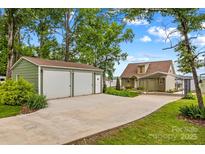 Charming home featuring a detached two-car garage, a covered carport, and lush landscaping at 270 Yachtsman Dr, Salisbury, NC 28146