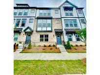 Beautiful townhome featuring brick facade, multiple windows, and well-maintained landscaping at 353 Jetton St, Davidson, NC 28036