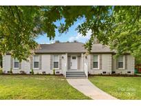 Charming single-story home featuring a brick facade, landscaped front yard and a welcoming front entrance at 3801 Rea Rd, Charlotte, NC 28226
