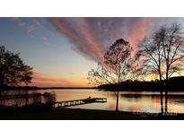 Scenic lake view at sunset with a long dock and colorful sky, perfect for relaxing or entertaining at 4574 Ivy Run Ln, Denver, NC 28037