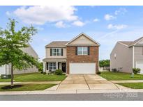 Charming two-story home with a brick and siding exterior, well-manicured lawn, and an inviting front porch at 515 Benford Ln, Stanley, NC 28164