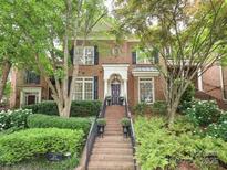Beautiful two-story brick home with mature trees and manicured landscaping at 525 Queens Rd, Charlotte, NC 28207