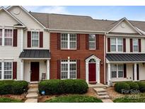 Charming townhome featuring brick facade, burgundy shutters, and well-maintained landscaping at 7943 Mariners Pointe Cir, Denver, NC 28037