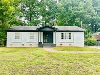 Charming single-story home with a freshly painted white brick exterior and well-maintained front lawn at 901 Echo Glen Rd, Charlotte, NC 28213