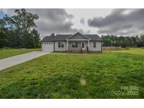 Charming single-story home with a well-manicured lawn, attached garage, and inviting front porch at 108 Devynne Ct, Salisbury, NC 28146