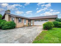 Traditional brick home featuring an attached garage and well-manicured landscaping at 1410 Patterson St, China Grove, NC 28023