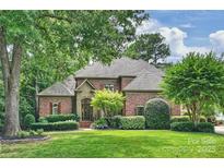 Charming brick home featuring lush landscaping and a well-manicured lawn in a serene, tree-lined neighborhood at 14652 Villalonga Ln, Charlotte, NC 28277