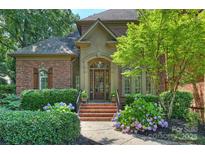 Charming brick home featuring a welcoming front entrance and landscaped with verdant bushes and vibrant hydrangea at 14652 Villalonga Ln, Charlotte, NC 28277