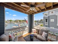 Relax on the cozy balcony with waterfront views, comfortable seating, and a charming ceiling fan at 18679 Vineyard Point Ln, Cornelius, NC 28031
