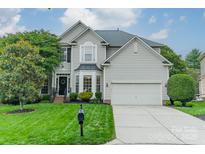 Charming two-story home boasts a manicured lawn, mature trees, and a classic architectural design at 211 Tyndale Ct, Waxhaw, NC 28173