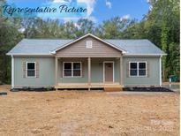 Charming exterior of home featuring a cozy front porch and well-manicured lawn at 317 N Cemetery St, Richfield, NC 28137