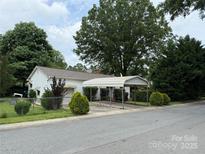 Charming home featuring a carport and a well-maintained front yard with mature trees at 3500 Blessing St, Charlotte, NC 28208
