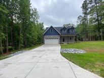 Charming two-story home featuring a blue and gray exterior, a spacious driveway, and a well-manicured lawn at 4435 Cornett Dr # 30, Iron Station, NC 28080