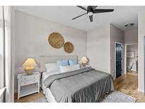 Bright bedroom features a ceiling fan, comfortable bed with blue pillows, and stylish decor at 482 New Bern Station Ct, Charlotte, NC 28209
