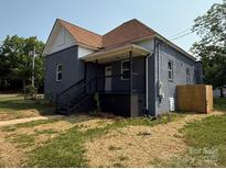 Charming exterior elevation featuring a covered front porch, gray brick, and freshly landscaped yard at 506 N Styers St, Cherryville, NC 28021