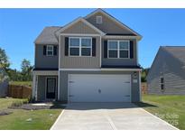 Charming two-story home featuring a two-car garage, manicured lawn, and classic architectural details at 642 Lamorak Pl, Richburg, SC 29729