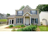 Charming two-story home featuring blue shutters, a welcoming front porch, and a beautifully landscaped front yard at 7046 Dorn Cir, Charlotte, NC 28212