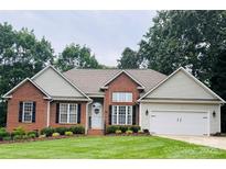 Charming brick home featuring a well-manicured lawn and an attached two-car garage at 104 Laura Ct, Cherryville, NC 28021