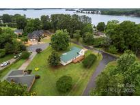 Expansive property with a charming home, lush green lawn, and stunning lake views at 105 Pelican Ct, Mooresville, NC 28117