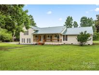 Charming home featuring a covered front porch, a manicured lawn, and beautiful landscaping at 105 Pelican Ct, Mooresville, NC 28117
