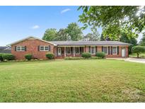 Charming brick home with well-manicured lawn, complemented by lush greenery and a welcoming entrance, perfect for curb appeal at 1155 Melrose Dr, Rock Hill, SC 29732