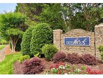 Stone community sign for Crosswinds surrounded by green foliage and colorful red, white, and green manicured ground cover at 12904 Windy Lea Ln, Huntersville, NC 28078