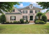 Charming brick two-story home featuring manicured landscaping and black shutters at 13716 Glen Abbey Dr, Charlotte, NC 28278