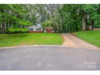 Charming single-story brick home with a well-maintained front yard and lush trees at 1401 Hillwood Ct, Charlotte, NC 28210