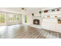 Bright living room featuring a cozy fireplace and built-in shelving at 14027 Hackamore Dr, Matthews, NC 28105