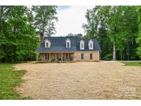 Charming brick home with a cozy front porch, nestled among mature trees at 15025 Barbee Rd, Stanfield, NC 28163