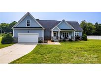 Charming single-Gathering home featuring a well-manicured lawn, a 2-car garage, and a cozy front porch at 1858 Brevard Place Rd, Iron Station, NC 28080