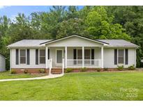 Charming single-story home featuring a metal roof, covered porch, and well-manicured front lawn at 1983 Burkin Rd, McConnells, SC 29726