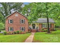 Charming brick home featuring a well-manicured lawn and inviting front porch at 2301 Seth Thomas Rd, Charlotte, NC 28210