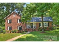 Charming brick home featuring a welcoming front porch and beautifully landscaped front yard at 2301 Seth Thomas Rd, Charlotte, NC 28210