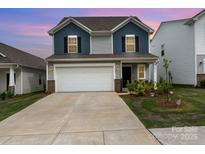 Charming two-story home featuring blue and gray siding, a two-car garage, and well-maintained landscaping at 2317 Trollinger Dr, Catawba, NC 28609