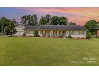 Charming one-story home with brick exterior, lush lawn, and a separate garage at 309 Ogden Dr, Gastonia, NC 28056