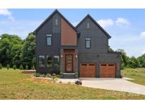Contemporary two-story home features a two-car garage, modern siding and professional landscaping at 309 Sain Rd, Statesville, NC 28625