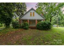 Charming two-story home with brick-columned front porch and lush landscaping at 520 Eastwood Park Cir, Albemarle, NC 28001