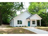 Charming, newly renovated one-story home features a bright blue door and pristine white siding at 617 English St, Monroe, NC 28110