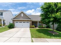 Charming single-story home boasts a stone-accented facade, attached two-car garage, and lush green lawn at 679 Cape Fear St, Fort Mill, SC 29715