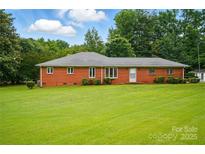 Charming single story brick home with a well-maintained lawn, mature trees, and a welcoming facade at 6900 Ridge Lane Rd, Charlotte, NC 28262