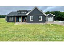 Charming home with dark siding, white trim, and a well-manicured lawn at 7133 Church Rd, Taylorsville, NC 28681