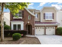 Charming two-story home featuring a two-car garage, brick facade, and meticulously landscaped front yard at 9429 Ridgeforest Dr, Charlotte, NC 28277