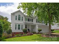 Charming two-story home boasts a manicured lawn and a classic white facade, creating a welcoming curb appeal at 10924 Owl Nest Ln, Charlotte, NC 28277