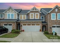 Charming townhouse featuring a stone facade, two-car garage, and well-maintained landscaping at 1126 Roderick Dr, Fort Mill, SC 29708