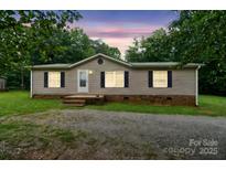 Charming single-story home with neutral siding, black shutters, and a well-manicured front lawn at 1245 Forest Ridge Rd, Bessemer City, NC 28016