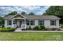 Charming single-story home featuring a covered porch, gray siding, black shutters, and colorful landscaping at 2843 Hopewell Church Rd, Sherrills Ford, NC 28673