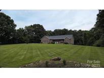 Charming single-story brick home features a well-manicured lawn and a wooded surround, offering privacy at 28835 Hartsell Rd, Albemarle, NC 28001