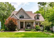 Charming home featuring stone accents, a cozy front porch, and lush landscaping at 2941 Forest Park Dr, Charlotte, NC 28209