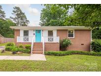Charming brick home with a bright turquoise front door and white trim at 4533 Gainesborough Rd, Charlotte, NC 28205